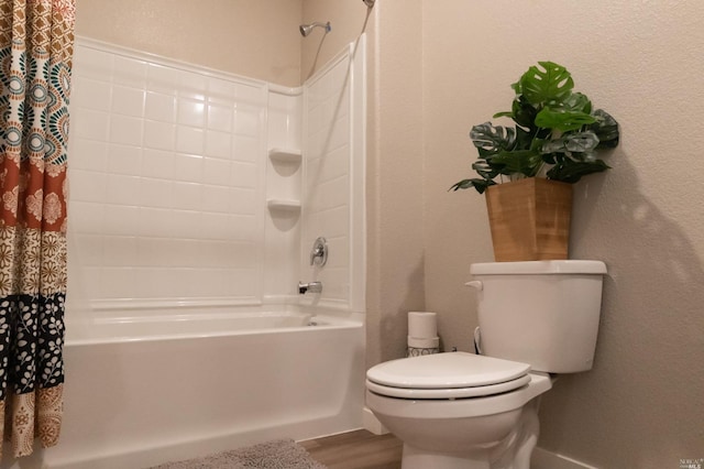 bathroom with shower / bath combo, hardwood / wood-style floors, and toilet