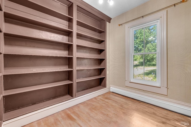 interior space featuring a baseboard heating unit and hardwood / wood-style floors