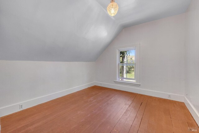 bonus room featuring vaulted ceiling and hardwood / wood-style floors