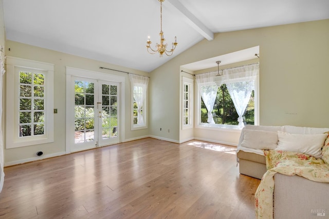 unfurnished living room featuring hardwood / wood-style flooring, lofted ceiling with beams, french doors, and a wealth of natural light