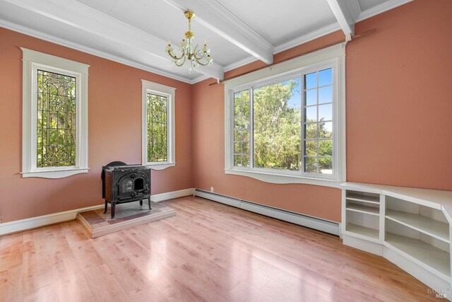 interior space featuring light wood-type flooring, a wood stove, ornamental molding, beamed ceiling, and a baseboard heating unit