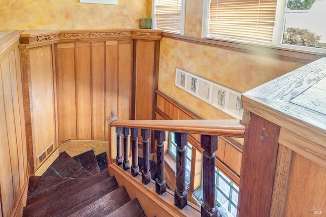 stairs featuring wood walls