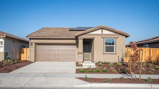 view of front facade featuring a garage and solar panels