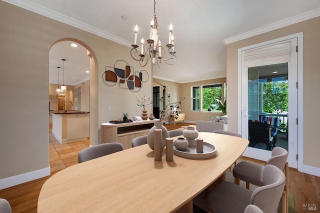 dining area featuring arched walkways, ornamental molding, and baseboards