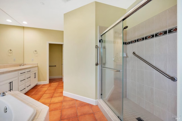 bathroom with a shower stall, baseboards, double vanity, tile patterned floors, and a sink