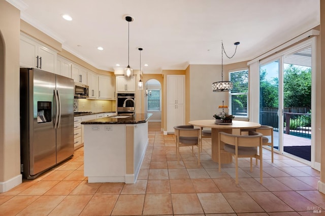 kitchen with tasteful backsplash, light tile patterned floors, ornamental molding, stainless steel appliances, and white cabinets
