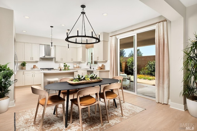 dining room featuring light hardwood / wood-style floors, a notable chandelier, and sink