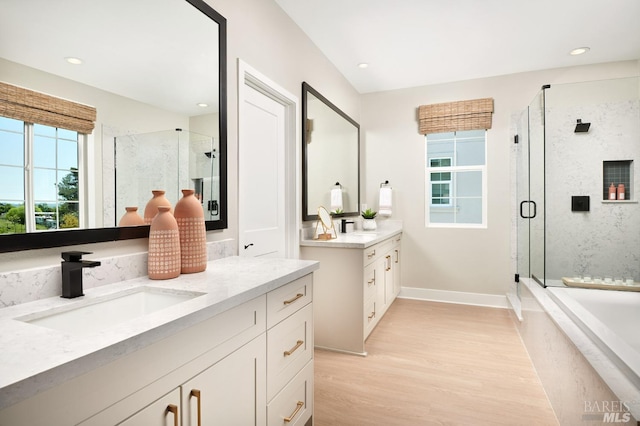 bathroom featuring vanity, separate shower and tub, wood-type flooring, and a fireplace