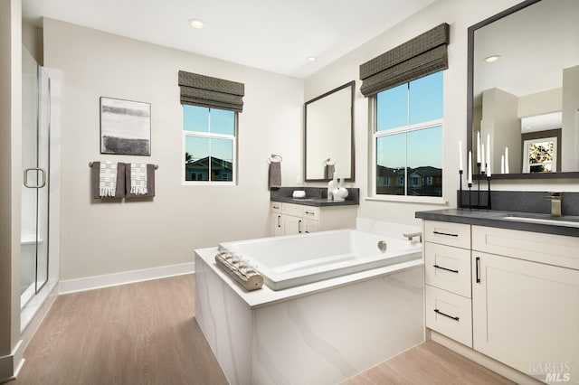 bathroom with shower with separate bathtub, vanity, and hardwood / wood-style flooring