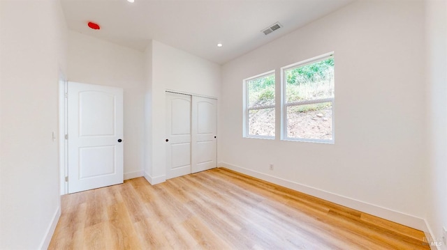 unfurnished bedroom with a closet and light hardwood / wood-style flooring