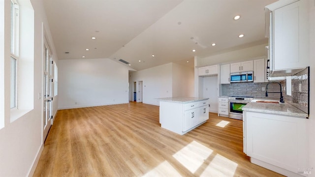 kitchen with white cabinetry, appliances with stainless steel finishes, a center island, and sink