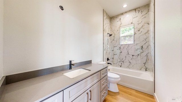 full bathroom featuring vanity, wood-type flooring, toilet, and tiled shower / bath