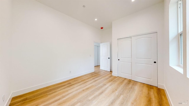 unfurnished bedroom with a closet and light hardwood / wood-style flooring