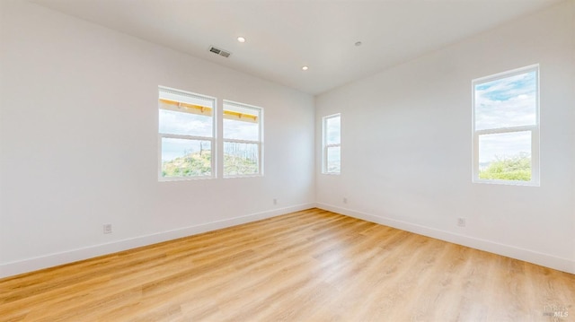 unfurnished room featuring light hardwood / wood-style floors and a healthy amount of sunlight