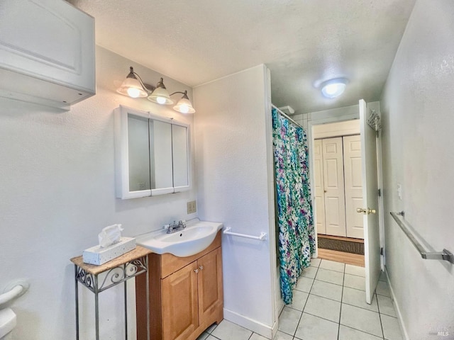 full bathroom with a textured ceiling, a wall mounted air conditioner, vanity, and tile patterned floors