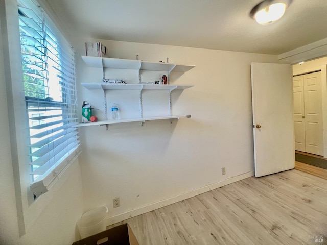 laundry area featuring light wood-type flooring and baseboards