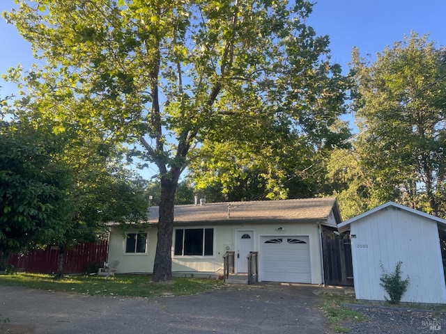 ranch-style home with fence, driveway, and an attached garage