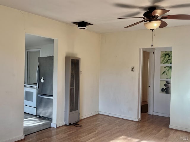 unfurnished room with baseboards and light wood-style floors