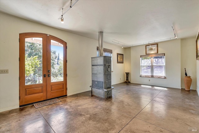 entrance foyer featuring arched walkways, french doors, plenty of natural light, and concrete floors