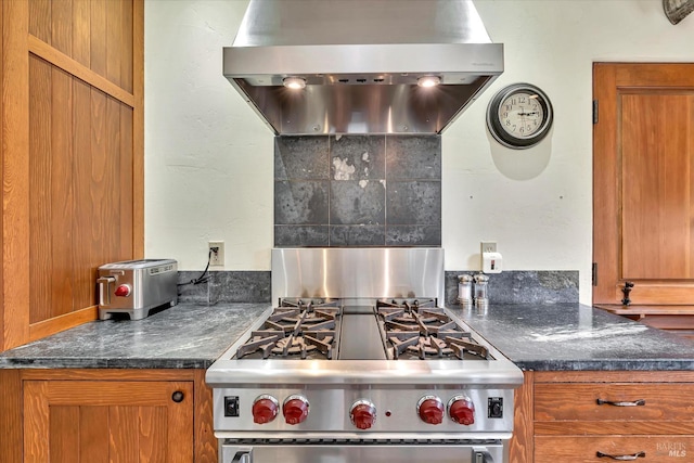 kitchen featuring high end stainless steel range, brown cabinetry, and range hood