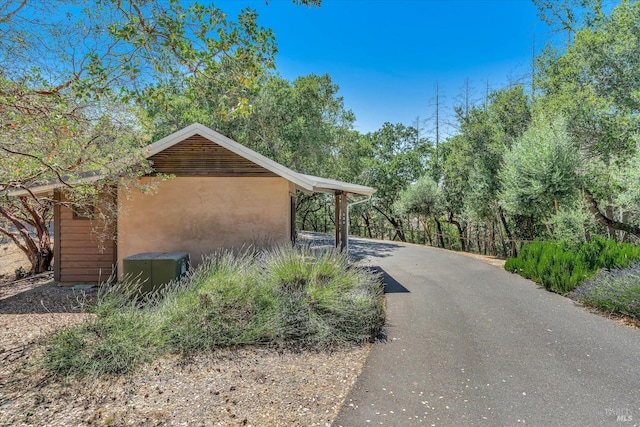 exterior space with aphalt driveway and stucco siding