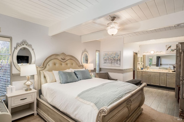 bedroom featuring beam ceiling, ceiling fan, sink, ensuite bathroom, and wood-type flooring