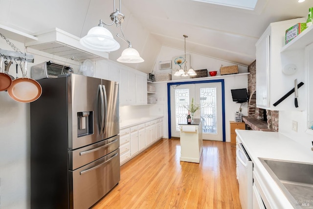 kitchen featuring pendant lighting, lofted ceiling, an inviting chandelier, stainless steel fridge with ice dispenser, and white cabinetry