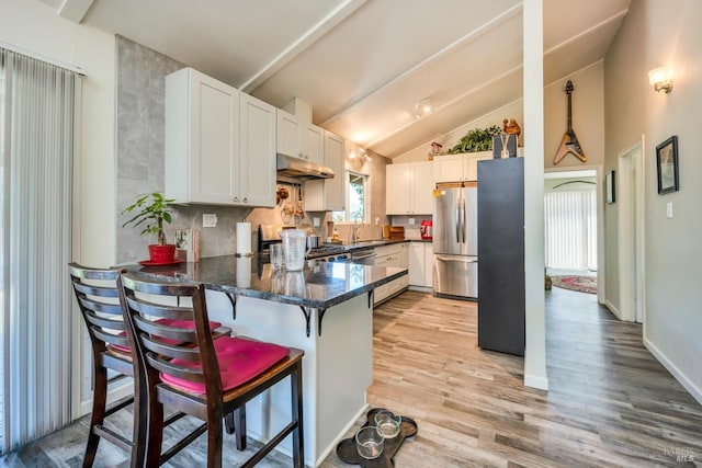 kitchen with kitchen peninsula, sink, white cabinets, and appliances with stainless steel finishes