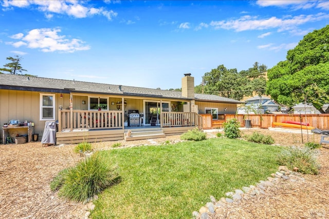 rear view of property with a yard and a wooden deck