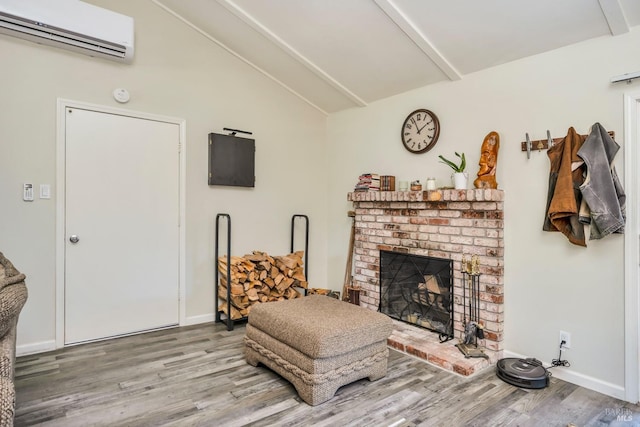 living area featuring a wall mounted AC, vaulted ceiling with beams, wood-type flooring, and a brick fireplace