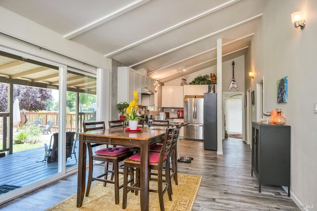 dining area featuring vaulted ceiling with beams and wood-type flooring