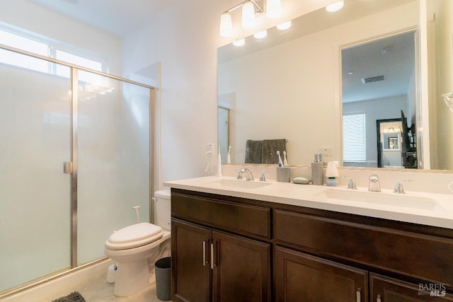 bathroom featuring vanity, toilet, and an enclosed shower