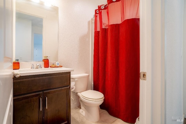 bathroom with vanity, toilet, and tile patterned flooring