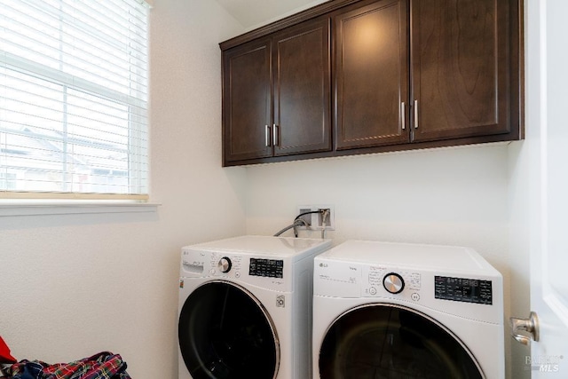 laundry room featuring separate washer and dryer and cabinets