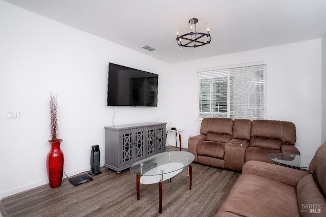 living room with wood-type flooring and a notable chandelier