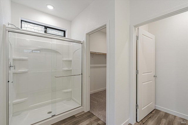 bathroom with wood-type flooring and a shower with shower door