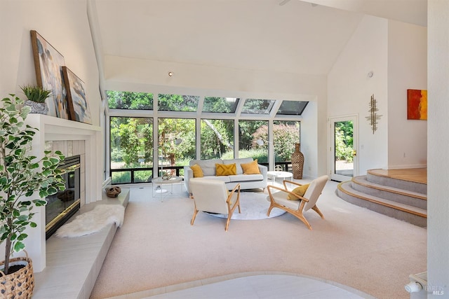 carpeted living room with high vaulted ceiling