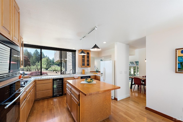 12430 Fiori Ln, Sebastopol, CA 95472 - kitchen with black appliances, track lighting, beverage cooler, and light wood-style floors