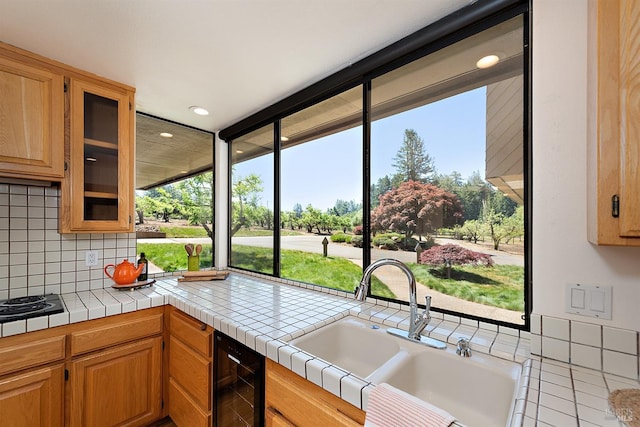 kitchen featuring backsplash, tile countertops, a wealth of natural light, and beverage cooler