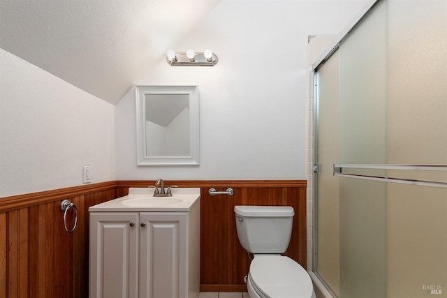 bathroom with a shower with door, vanity, vaulted ceiling, and toilet