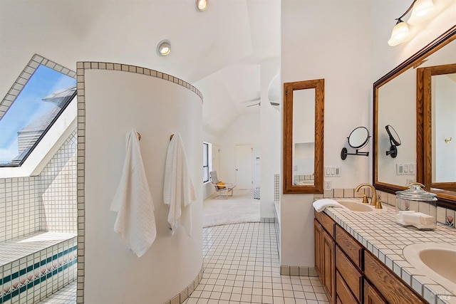 bathroom with tile patterned flooring, vanity, a bathing tub, and lofted ceiling