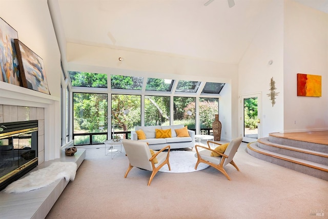 carpeted living room featuring a fireplace and high vaulted ceiling