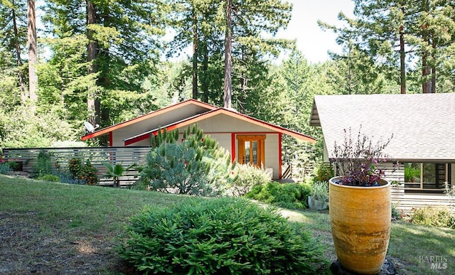 view of side of home featuring french doors and a lawn