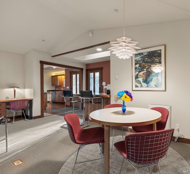 carpeted dining space featuring lofted ceiling