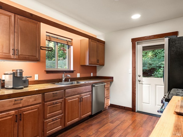 kitchen with sink, dark hardwood / wood-style flooring, wooden counters, and appliances with stainless steel finishes