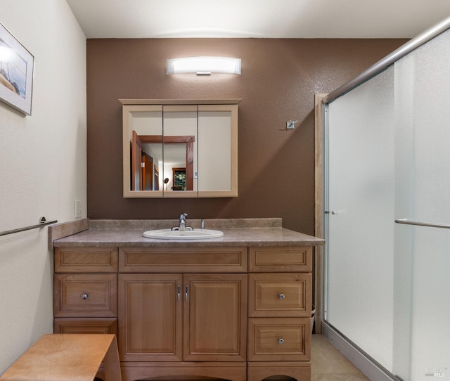 bathroom featuring tile patterned floors, vanity, and a shower with door