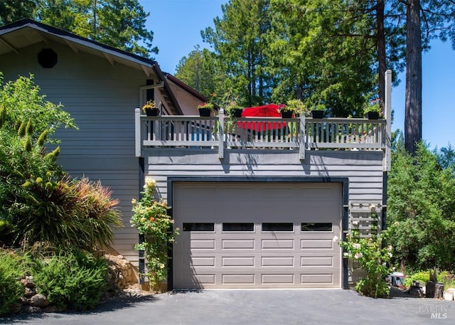 exterior space with a balcony, a garage, and a deck