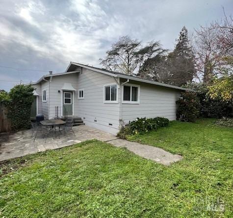 rear view of house featuring a lawn and a patio area