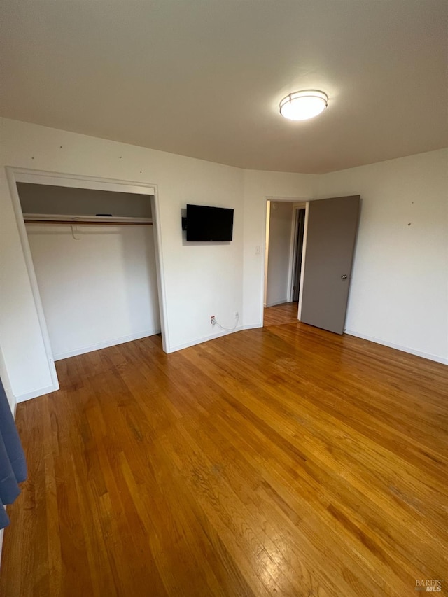 unfurnished bedroom with a closet and wood finished floors