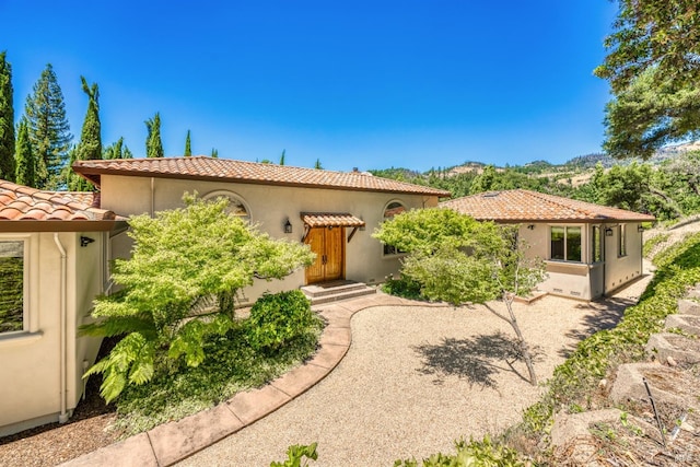 mediterranean / spanish house featuring a tile roof, a patio, and stucco siding